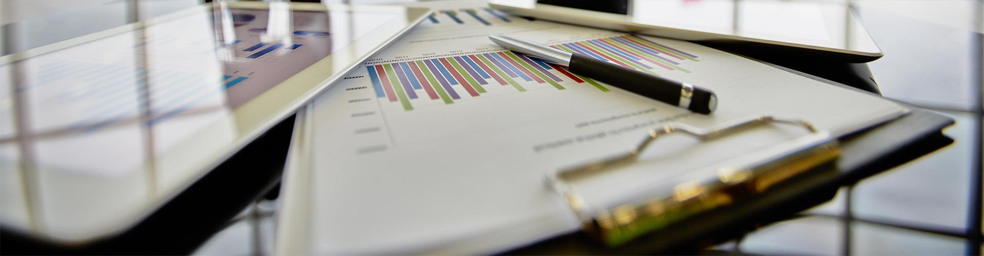 Cobros y pagos internacionales - Varios Informes y estadísticas encima de la mesa junto con una tableta digital Cobros y pagos internacionales - Varios Informes y estadísticas encima de la mesa junto con una tableta digital