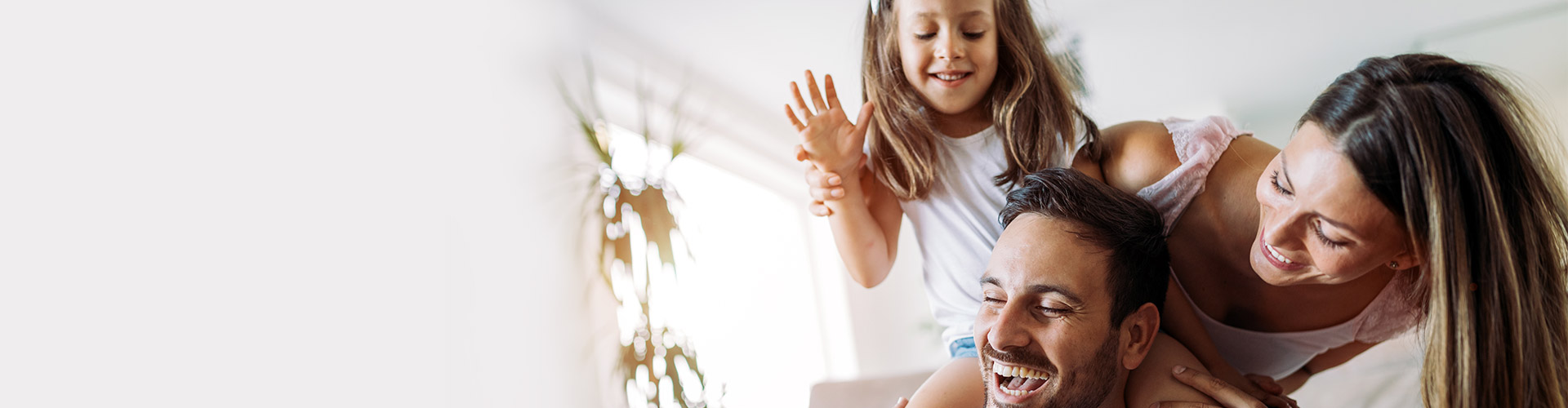 Más seguros para particulares - Familia joven jugando con su hija sonriendo y pasando un buen rato en el salón de su casa Más seguros para particulares - Familia joven jugando con su hija sonriendo y pasando un buen rato en el salón de su casa
