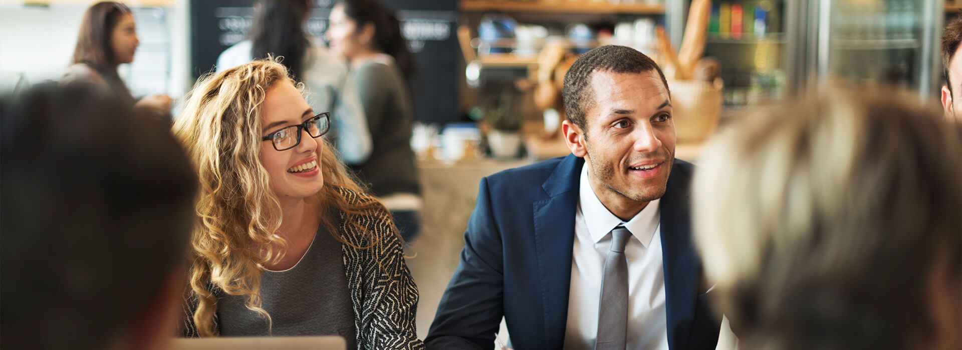 Servicio de Atención al Cliente - Dos personas con traje atendiendo a unos clientes en una oficina Servicio de Atención al Cliente - Dos personas con traje atendiendo a unos clientes en una oficina
