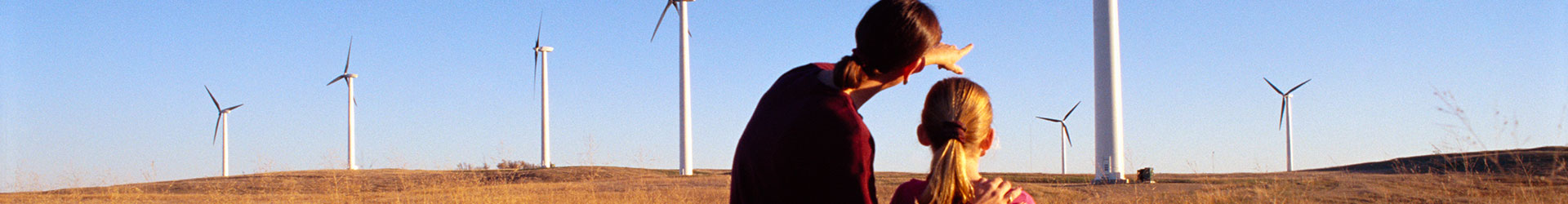 Sostenibles desde nuestras raíces - Madre e hija en un campo de trigo y molinos de viento Sostenibles desde nuestras raíces - Madre e hija en un campo de trigo y molinos de viento