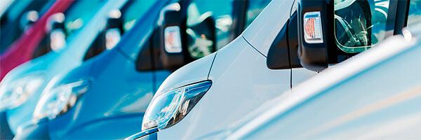 Seguro del Automovil para Empresas - Flota de furgonetas de empresa de diferentes colores aparcadas juntas entre ellas