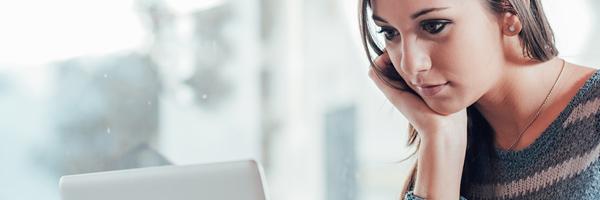 Bolsa y Mercados Particulares - Mujer de negocios joven concentrada trabajando frente a su portátil en la oficina