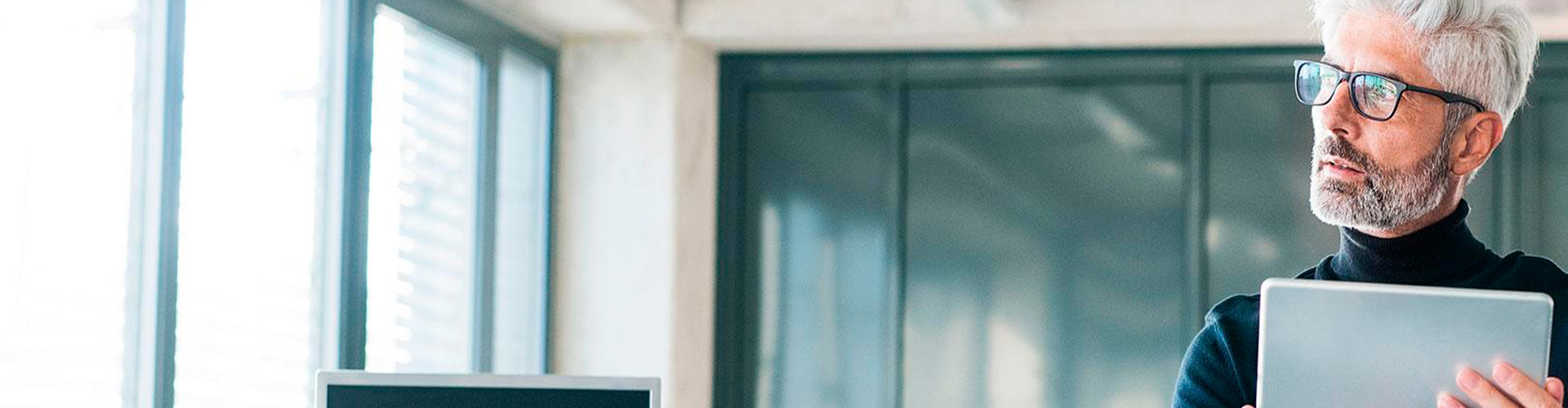 Bolsa y Mercados Empresas - Hombre de negocios de mediana edad con gafas y una tablet en las manos en la oficina Bolsa y Mercados Empresas - Hombre de negocios de mediana edad con gafas y una tablet en las manos en la oficina